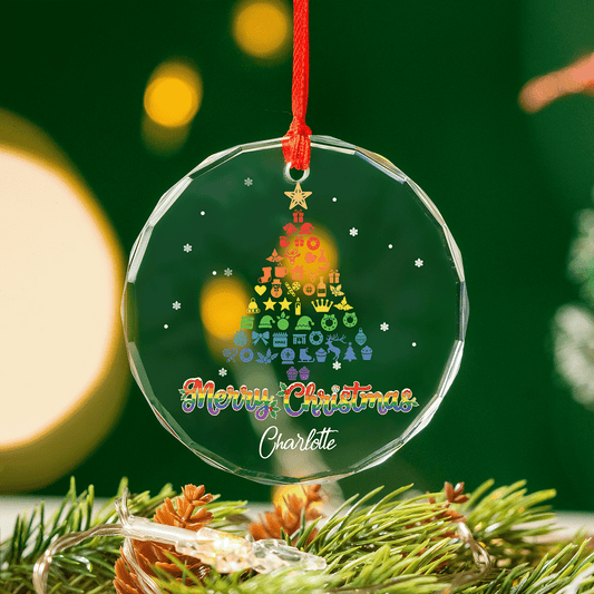 Pride Christmas tree glass ornament hanging against a green background