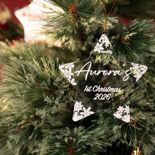 Baby 1st Christmas star ornament hanging on a flocked tree