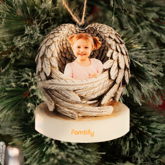 Angel wings baby photo ornament hanging on a tree