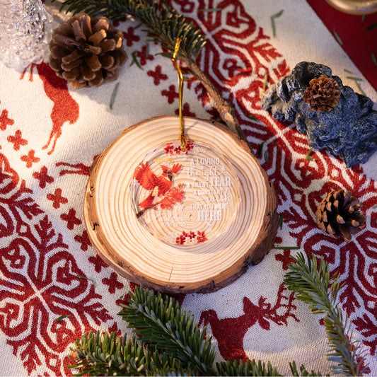 Cardinal memorial glass ornament on a wood slice on a Nordic cloth