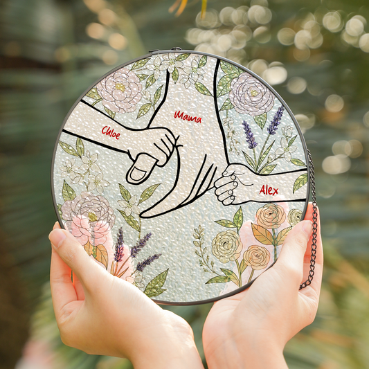 Round suncatcher with line art of mom's hand holding two children's hands, custom names and pastel flowers