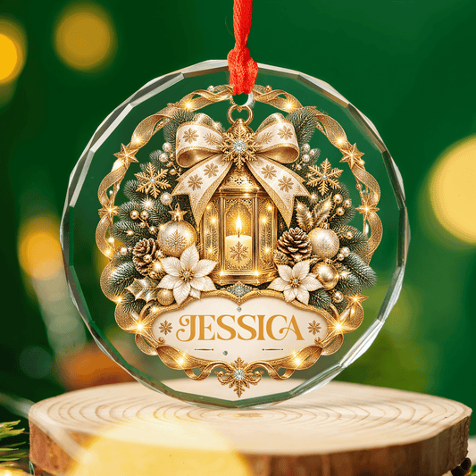 Golden lantern custom name glass ornament resting on a wood slice with warm holiday lights