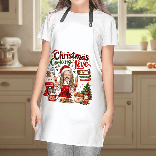 Woman wearing a white Christmas Cooking With Love apron with custom photo and name