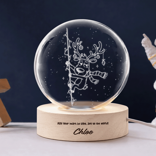 Climbing reindeer crystal ball night light with engraved May your heart be light message on a navy background