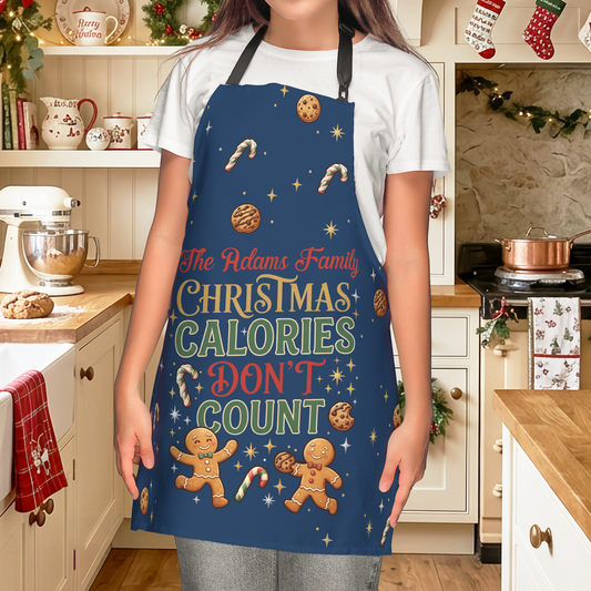 Woman wearing a navy Christmas Calories Don't Count apron with gingerbread men and custom family name