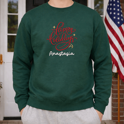 Man wearing a forest green red Happy Holidays name sweatshirt beside an American flag