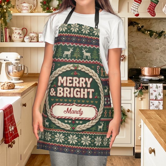 Woman wearing a green Fair Isle knit pattern Merry and Bright apron with custom name banner