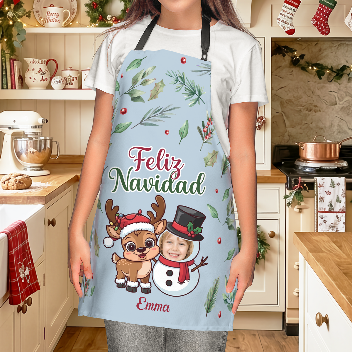 Woman wearing a light blue Feliz Navidad apron with reindeer and custom photo face snowman and name
