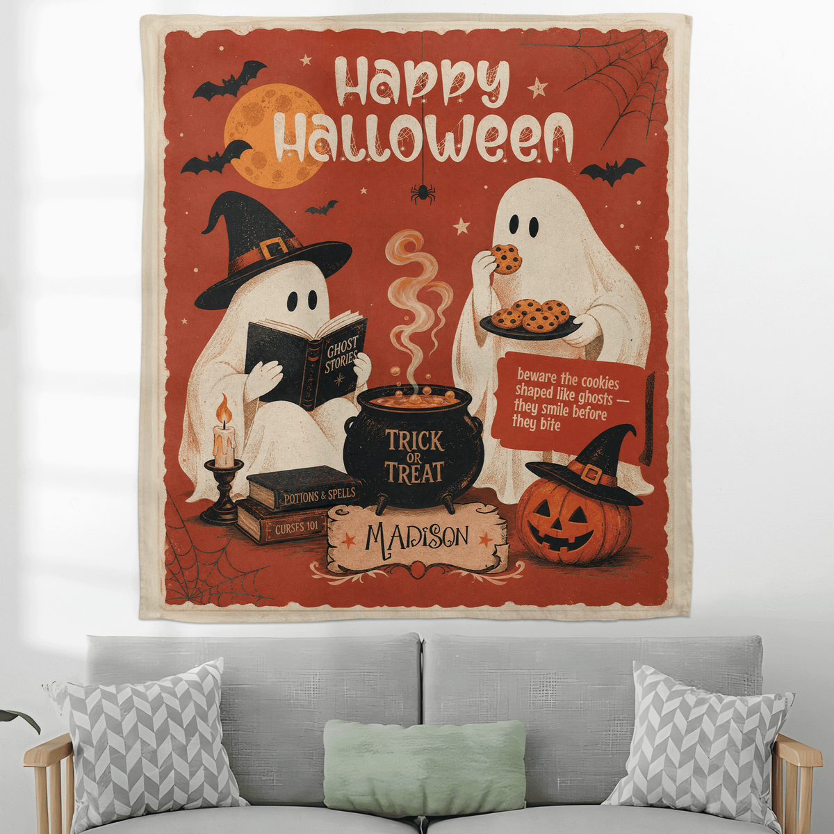 Personalized vintage Halloween ghost tapestry hanging above a grey sofa with patterned pillows