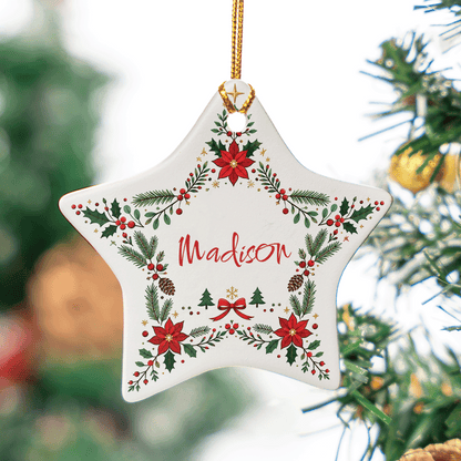 White ceramic star ornament with a poinsettia and holly wreath and a custom name in red script