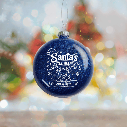 Navy blue glitter ball ornament printed Santa's Little Helper with a reindeer and custom name, bokeh background