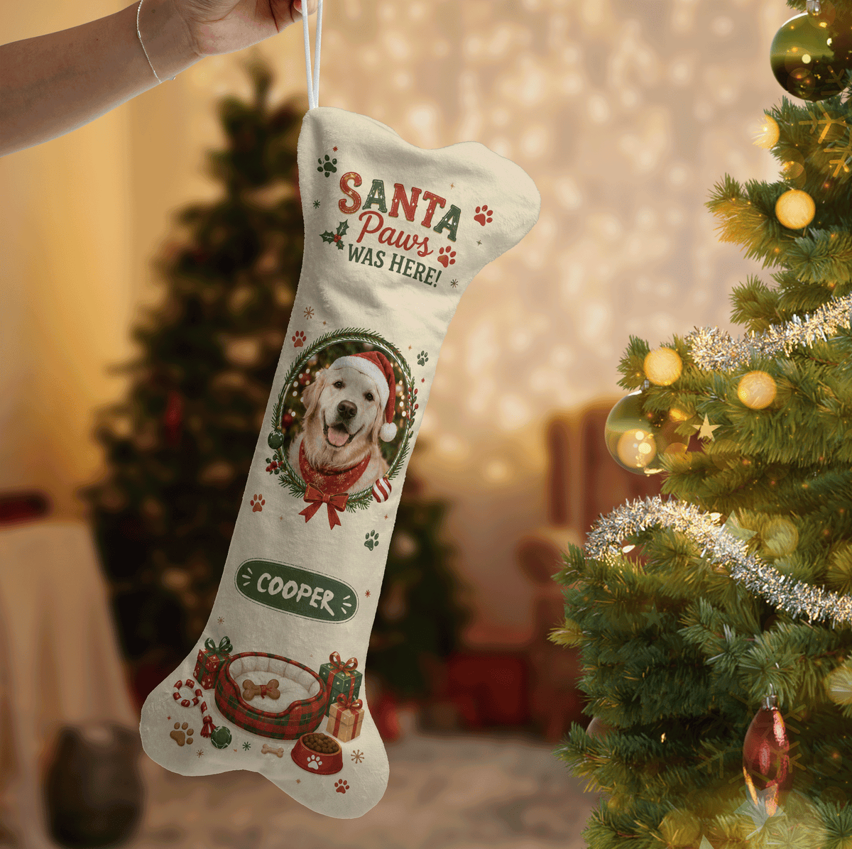 Hand holding a personalized dog photo bone stocking next to a Christmas tree