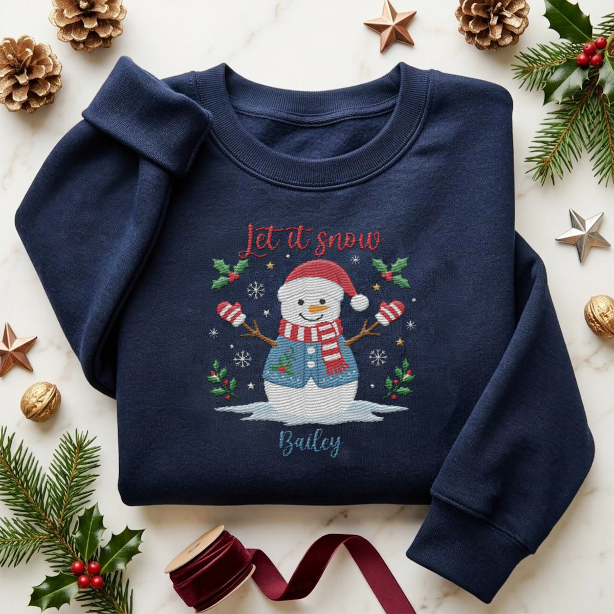 Navy sweatshirt embroidered with Let It Snow, a snowman in a Santa hat and scarf and a custom name