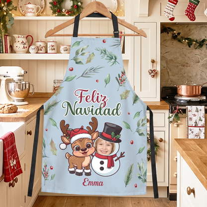 Light blue Feliz Navidad reindeer and snowman custom photo apron on a hanger in a kitchen