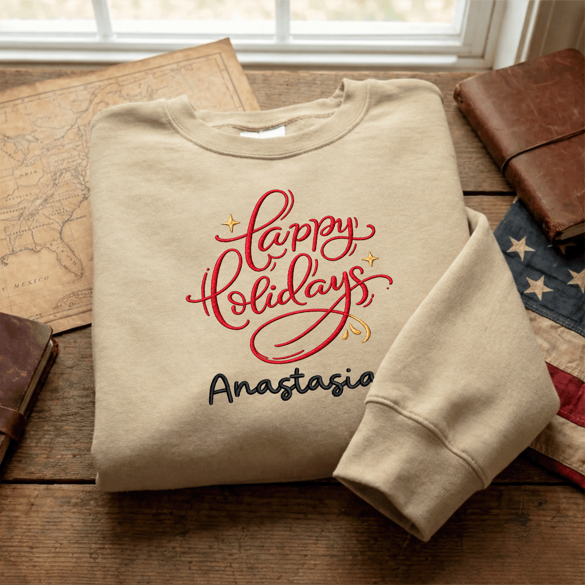 Sand red Happy Holidays name sweatshirt folded on a map with an American flag
