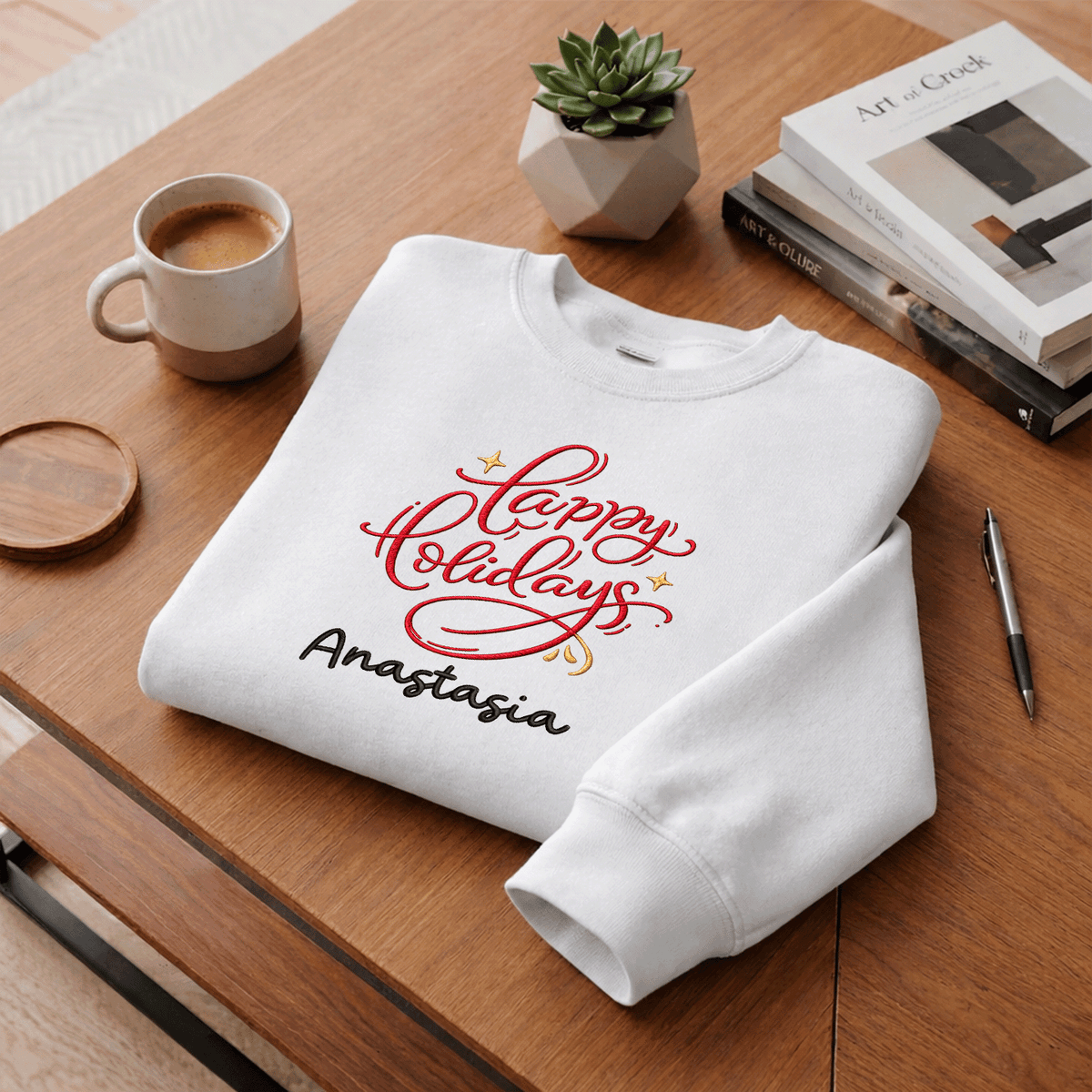 White red Happy Holidays custom name sweatshirt folded on a desk with coffee