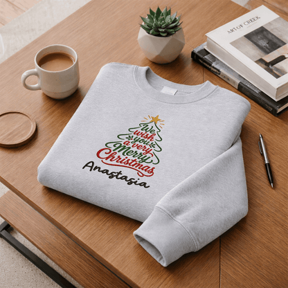 Heather grey We Wish You a Merry Christmas sweatshirt folded on a desk