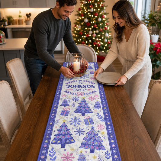 Couple setting a table with a lavender winter trees and snowflakes quilted runner in a kitchen