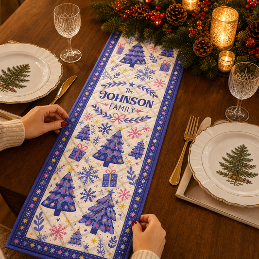 Hands placing a royal blue bordered quilt runner with lavender Christmas trees, pink snowflakes and custom family name