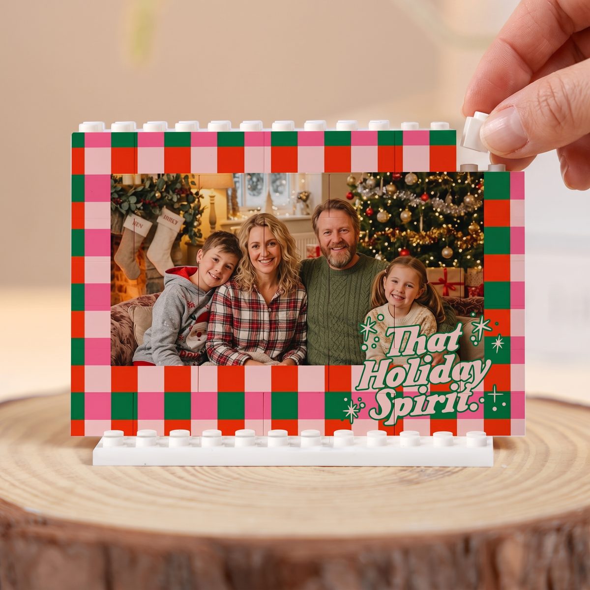 Hand placing a brick on the That Holiday Spirit Checkered family photo building block frame