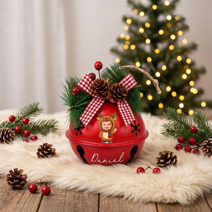 Personalized baby reindeer photo jingle bell ornament on a festive table