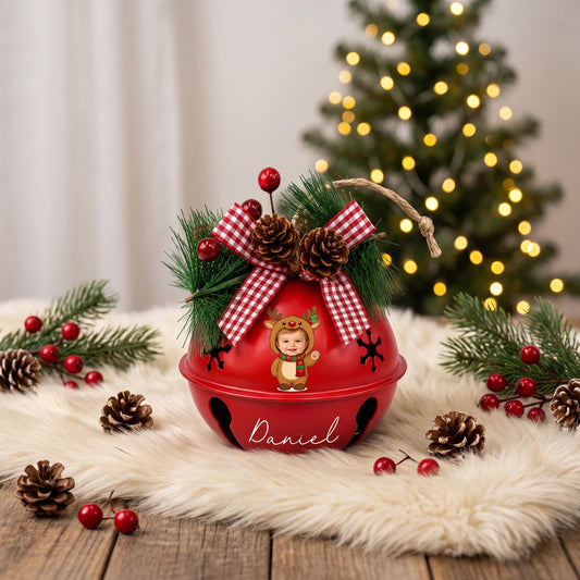 Personalized baby reindeer photo jingle bell ornament on a festive table