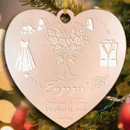 Rose gold mirrored heart ornament engraved with champagne glasses, a dress and tux, Engaged, two names and an October 2026 date