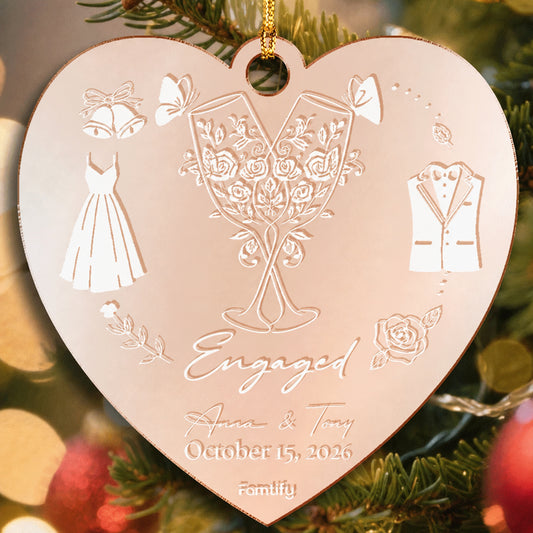 Rose gold mirrored heart ornament engraved with champagne glasses, a dress and tux, Engaged, two names and an October 2026 date