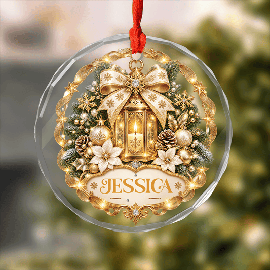 Round clear glass ornament printed with a golden lantern, poinsettias, festive bow and a custom name