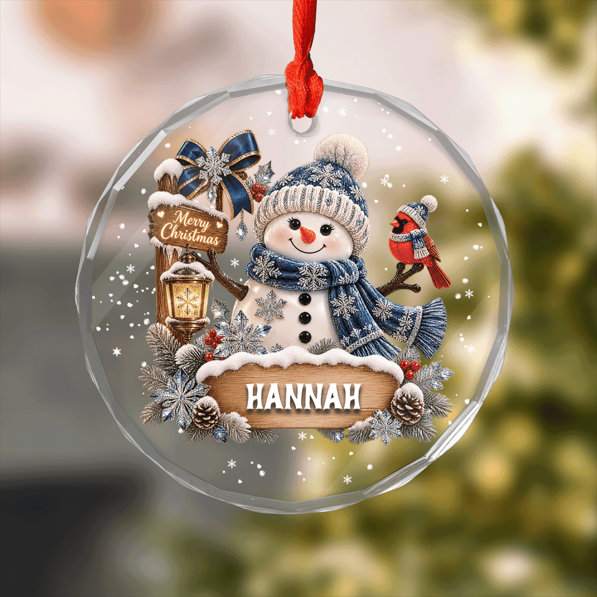 Round clear glass ornament printed with a snowman, cardinal, Merry Christmas sign and a custom name