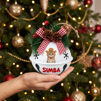 Personalized gingerbread pet jingle bell ornament held in hand by a Christmas tree