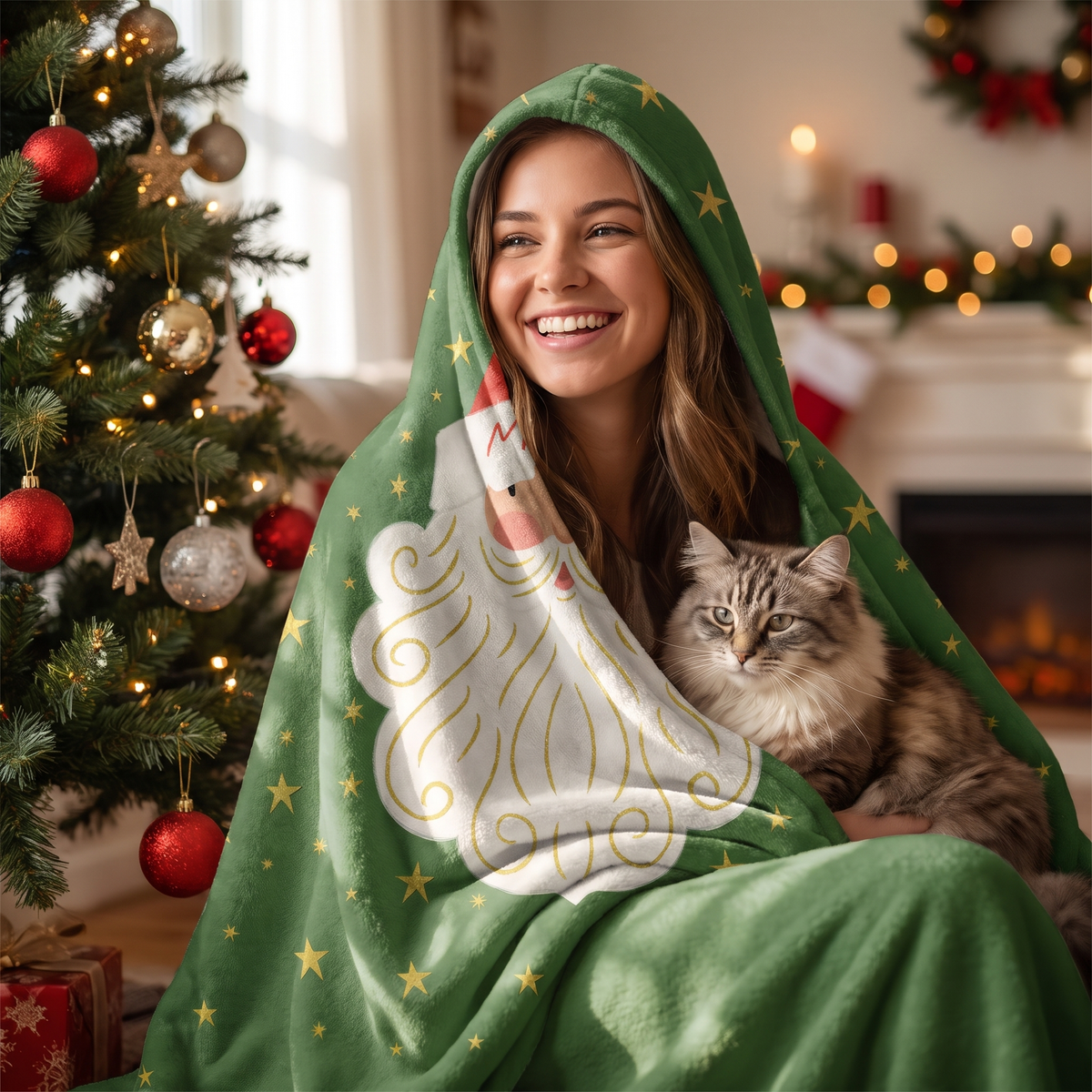 Smiling woman snuggled in the Santa Face Golden Stars hooded blanket with her cat by the Christmas tree