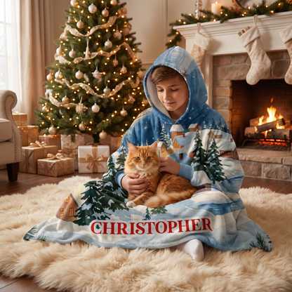 Child wrapped in the Santa Sleigh Snowy Village hooded blanket holding a cat by the Christmas tree