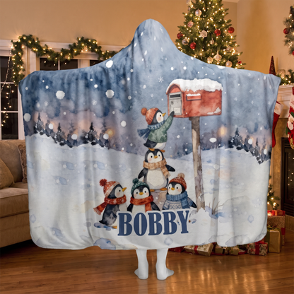 Penguins Snowy Mailbox hooded blanket worn in a cozy Christmas living room, back view