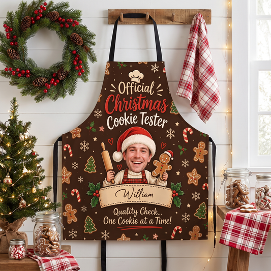 Brown Official Christmas Cookie Tester apron with custom photo face, gingerbread man and name, on a hook