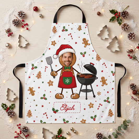 White gingerbread man apron with custom photo face grilling on a BBQ and custom name, flat lay