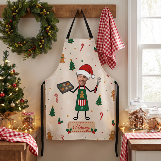 Cream gingerbread man custom name apron hanging on a wall hook by a wreath and gingham towel