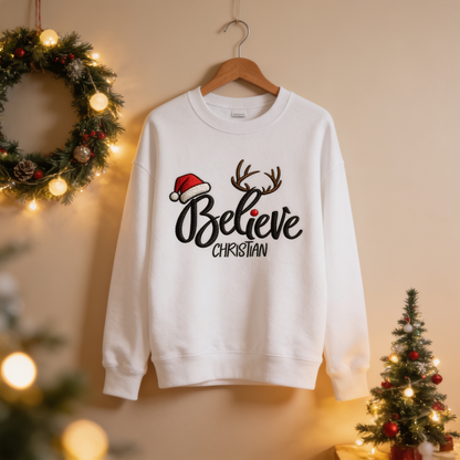 White Believe antlers name sweatshirt on a hanger by a wreath