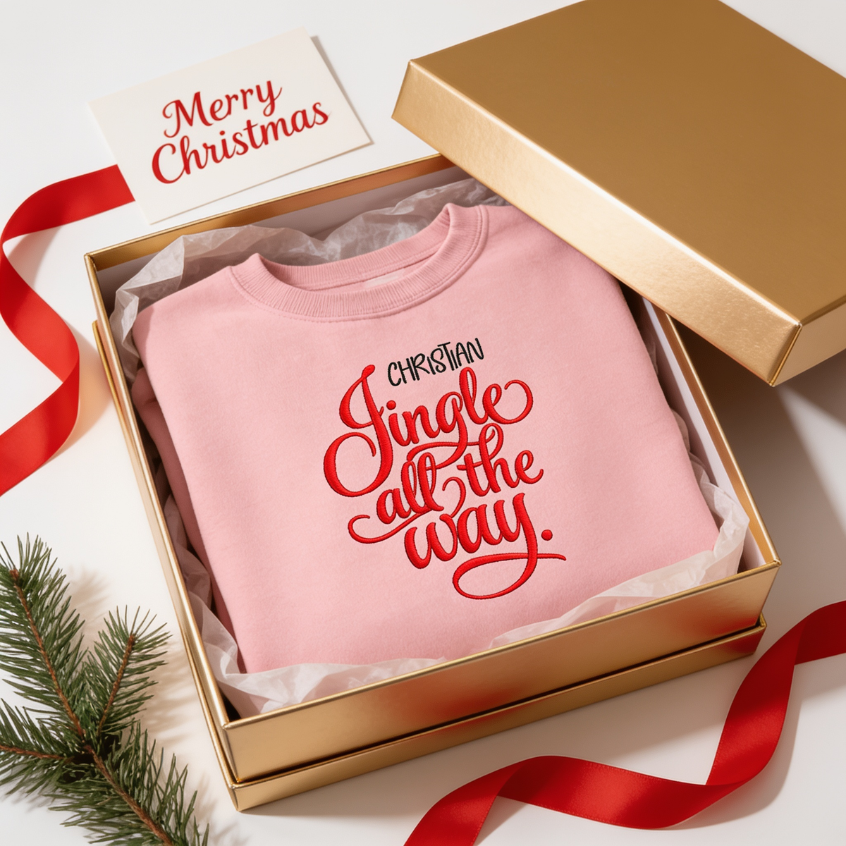 Pink Jingle All the Way custom name sweatshirt in a gold gift box with a Merry Christmas card