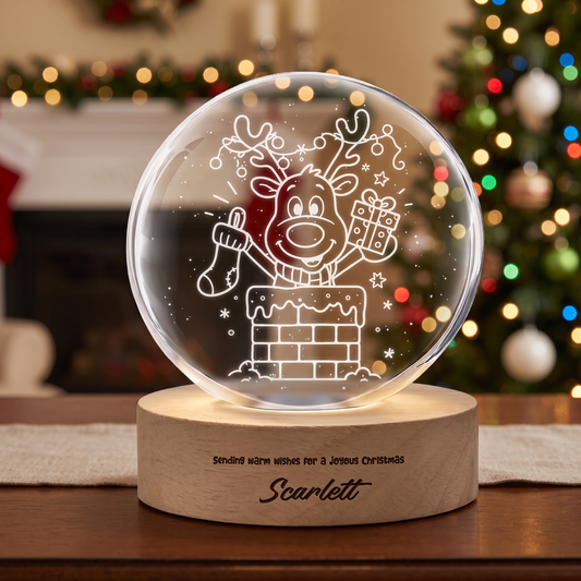 Glass crystal ball laser engraved with a reindeer in a chimney holding gifts on a wooden LED base with custom name