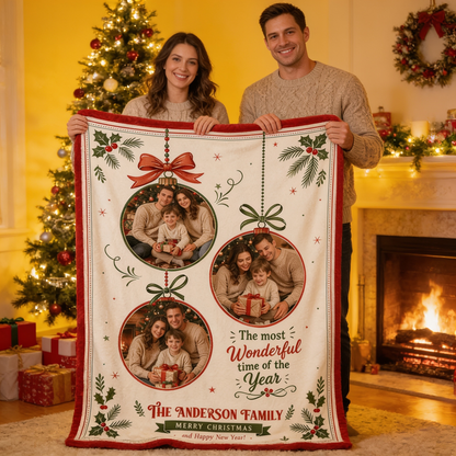Couple holding up a personalized three photo ornament Christmas blanket in front of the tree and fireplace