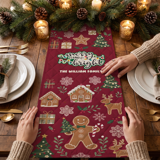 Hands placing a red quilt runner with Merry and Bright, custom family name, gingerbread man, reindeer and cookie houses