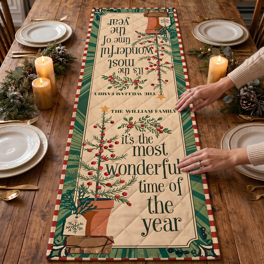 Hands placing a cream quilt runner reading It's the Most Wonderful Time of the Year with potted pine tree and red striped border