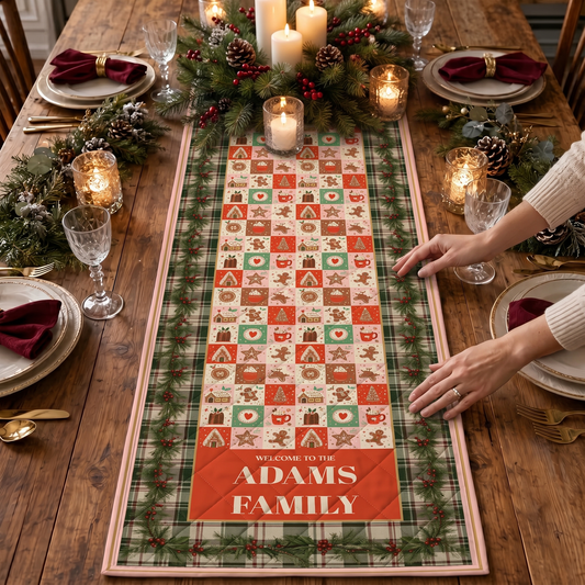 Hands smoothing a patchwork Christmas quilt table runner with gingerbread and tree squares, green plaid border and custom family name