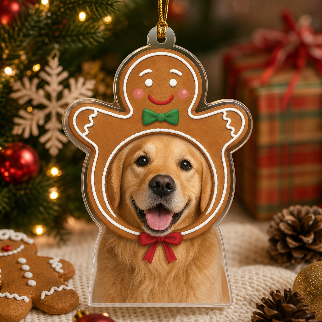 Gingerbread man pet ornament with a golden retriever photo beside gingerbread cookies and pinecones