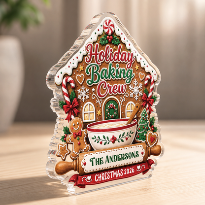 Side angle of the thick clear acrylic Holiday Baking Crew gingerbread house plaque on a light wooden surface