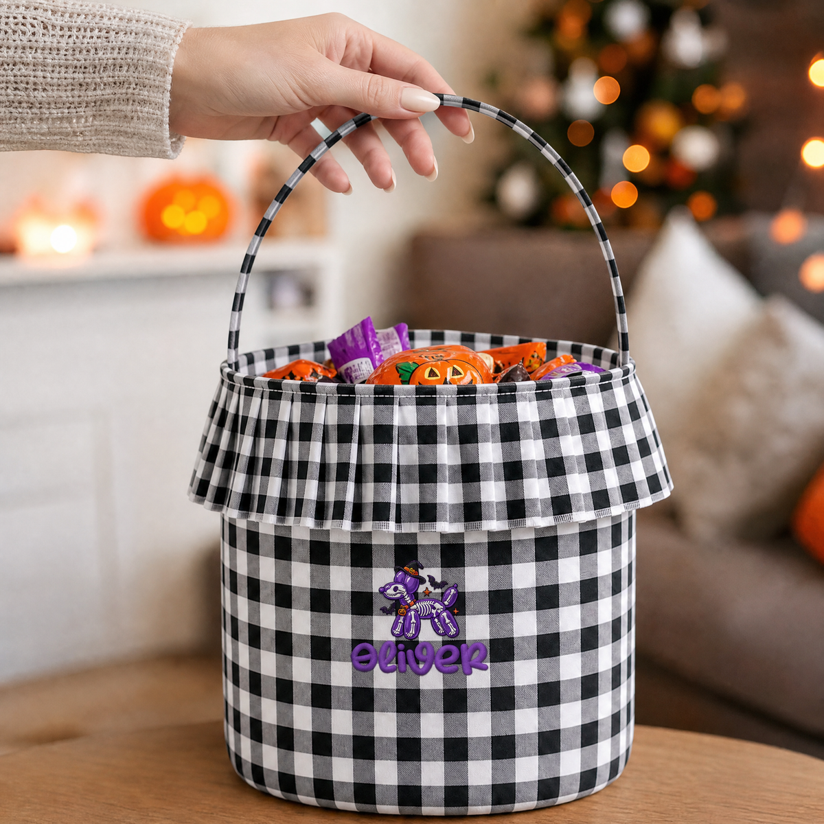 Hand lifting a black and white gingham ruffle basket with purple balloon dog and custom name embroidery