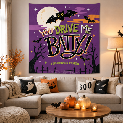 Custom family name You Drive Me Batty tapestry hanging over a cozy sectional with Boo pillows, pumpkins and candles