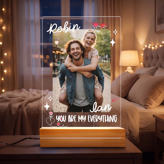 Acrylic night light with custom couple piggyback photo, names Robin and Ian and You Are My Everything on a wooden base by a bed