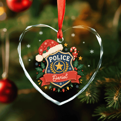 Heart shaped clear glass ornament with a Santa hat police badge, holly and a custom name banner